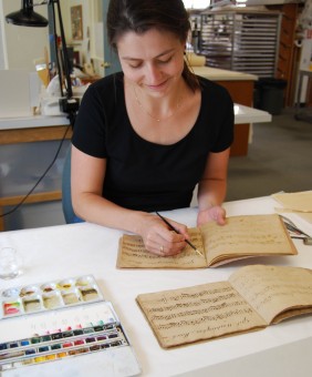 Conservator tones a page of a facsimile book