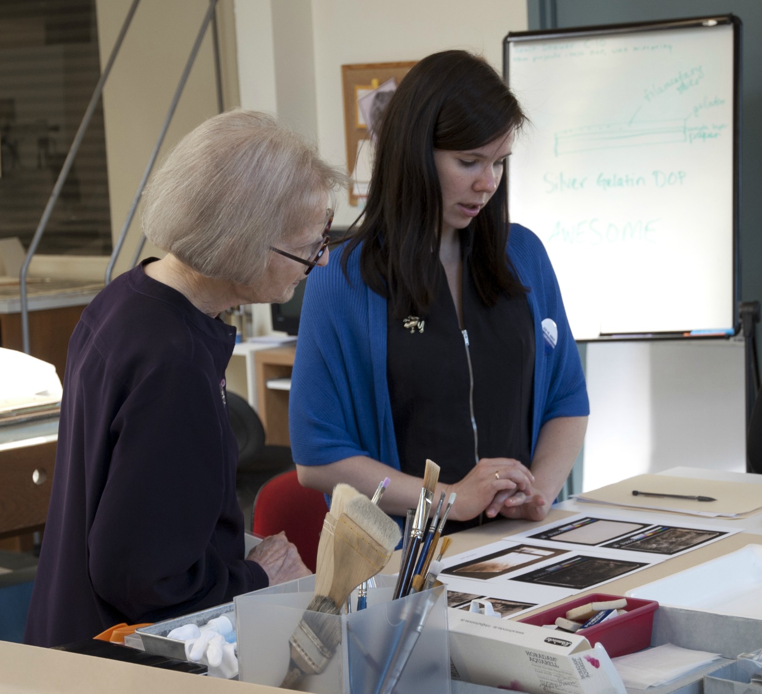Two conservators look at photographs