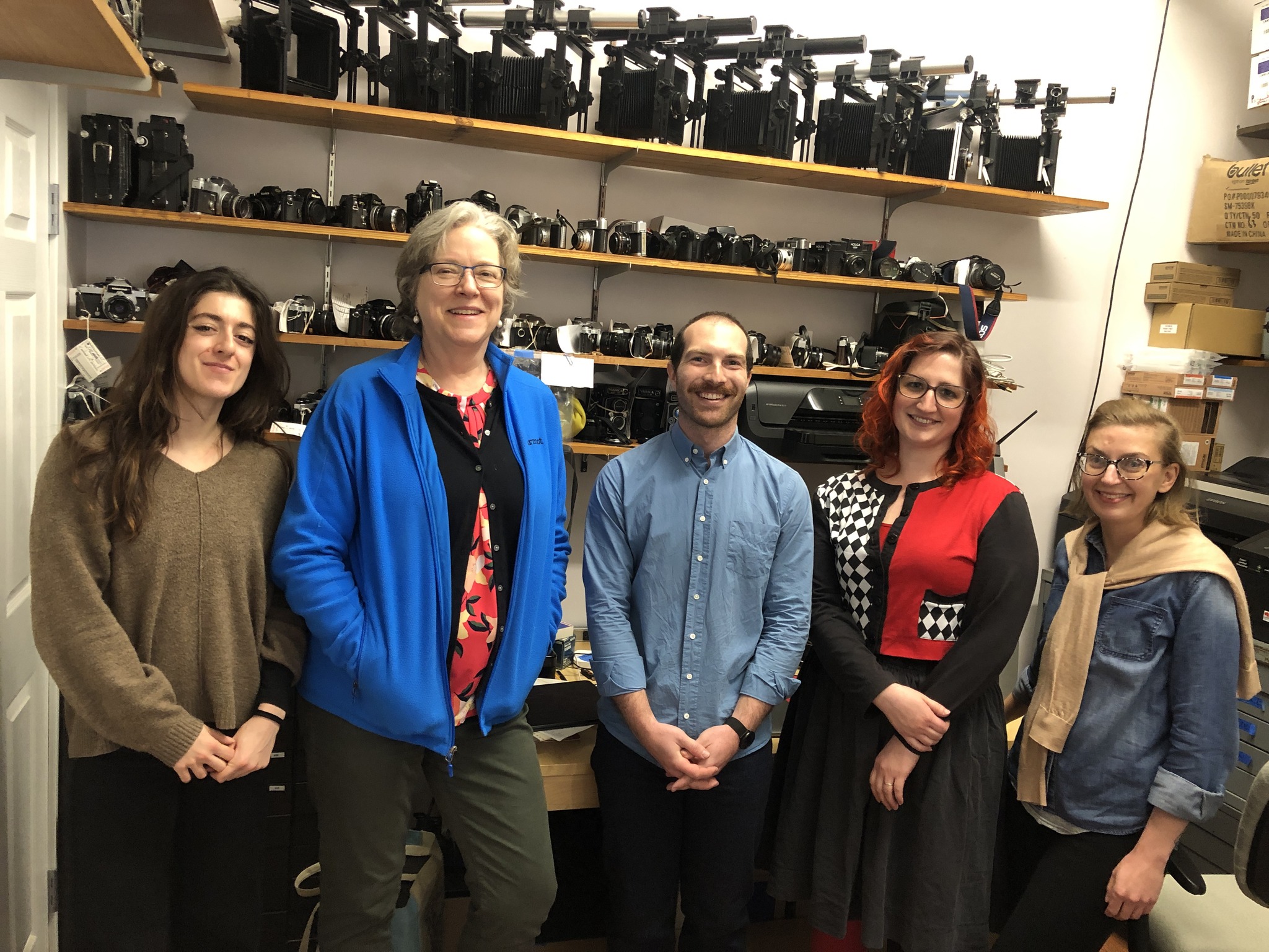 Group photo of CCAHA Photograph Conservation staff with a volunteer from The Halide Project, standing in front of shelves of photographic equipment and materials.
