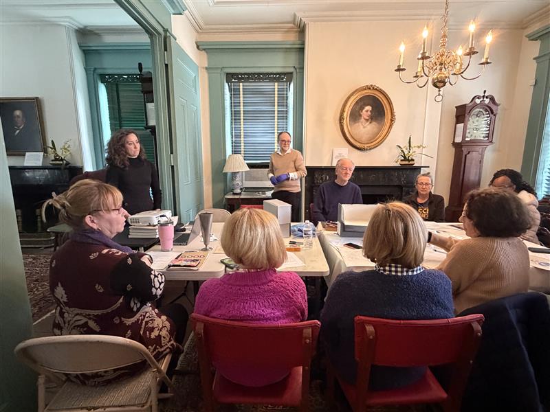 Participants gathered around a table with document boxes.