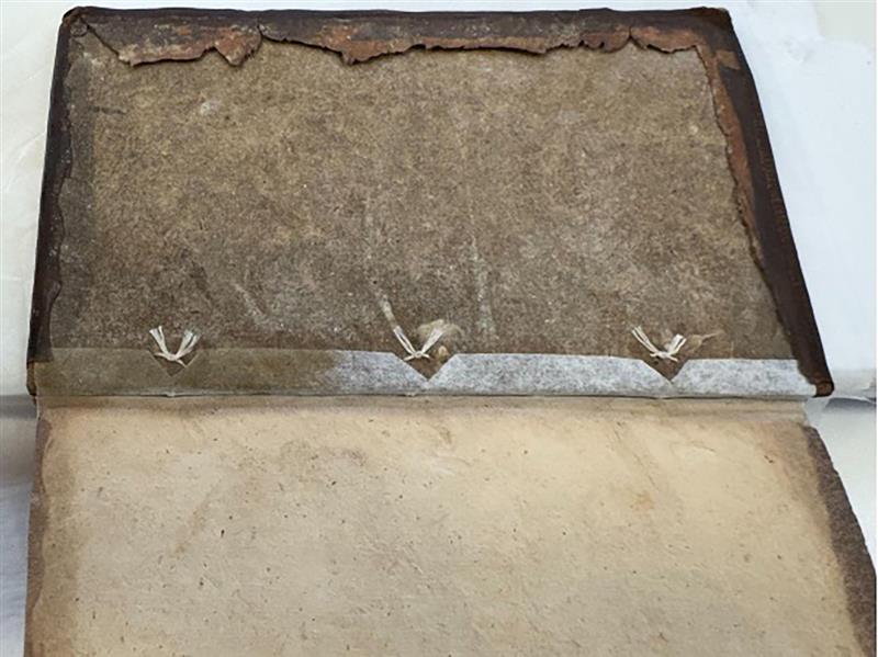The inside of a book, with tied threads of joint tackets reattach the board