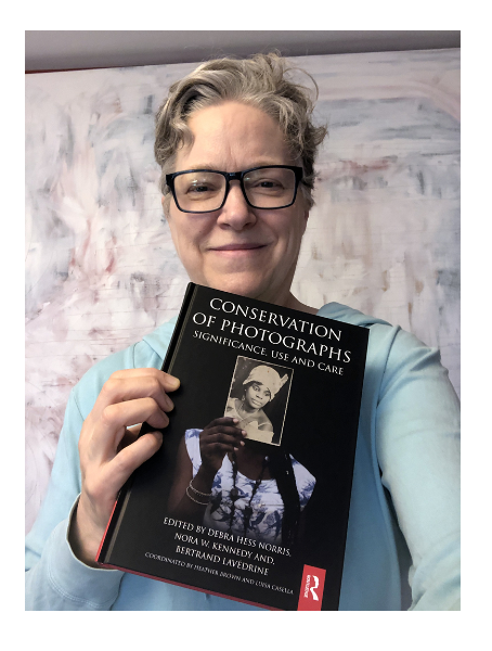 Barb, holding a copy of Conservation of Photographs, a reference book she contributed to