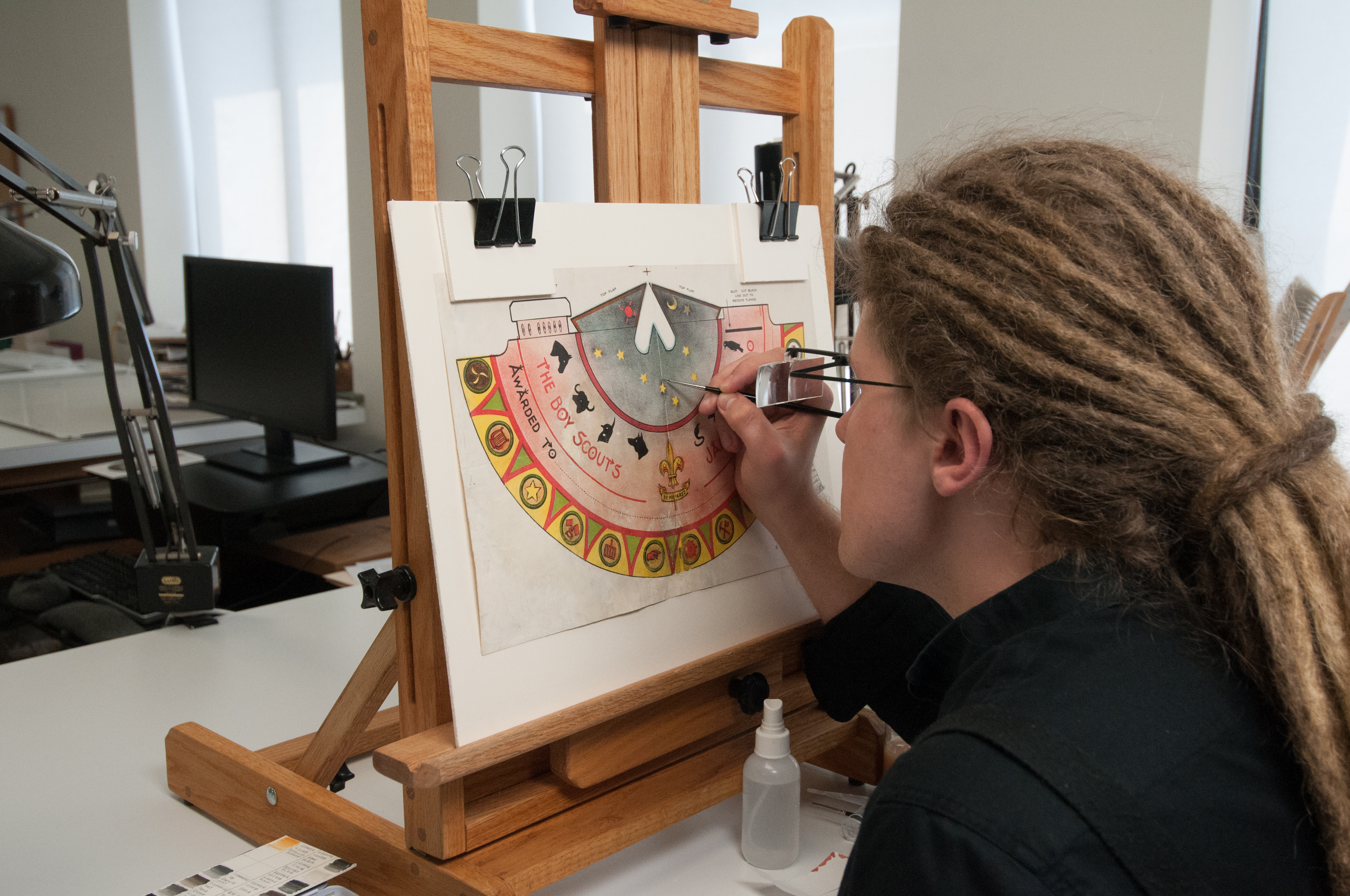 NEA Paper Conservation Fellow Benjamin Kirschner inpainting a 1920 Boy Scouts Jamboree award