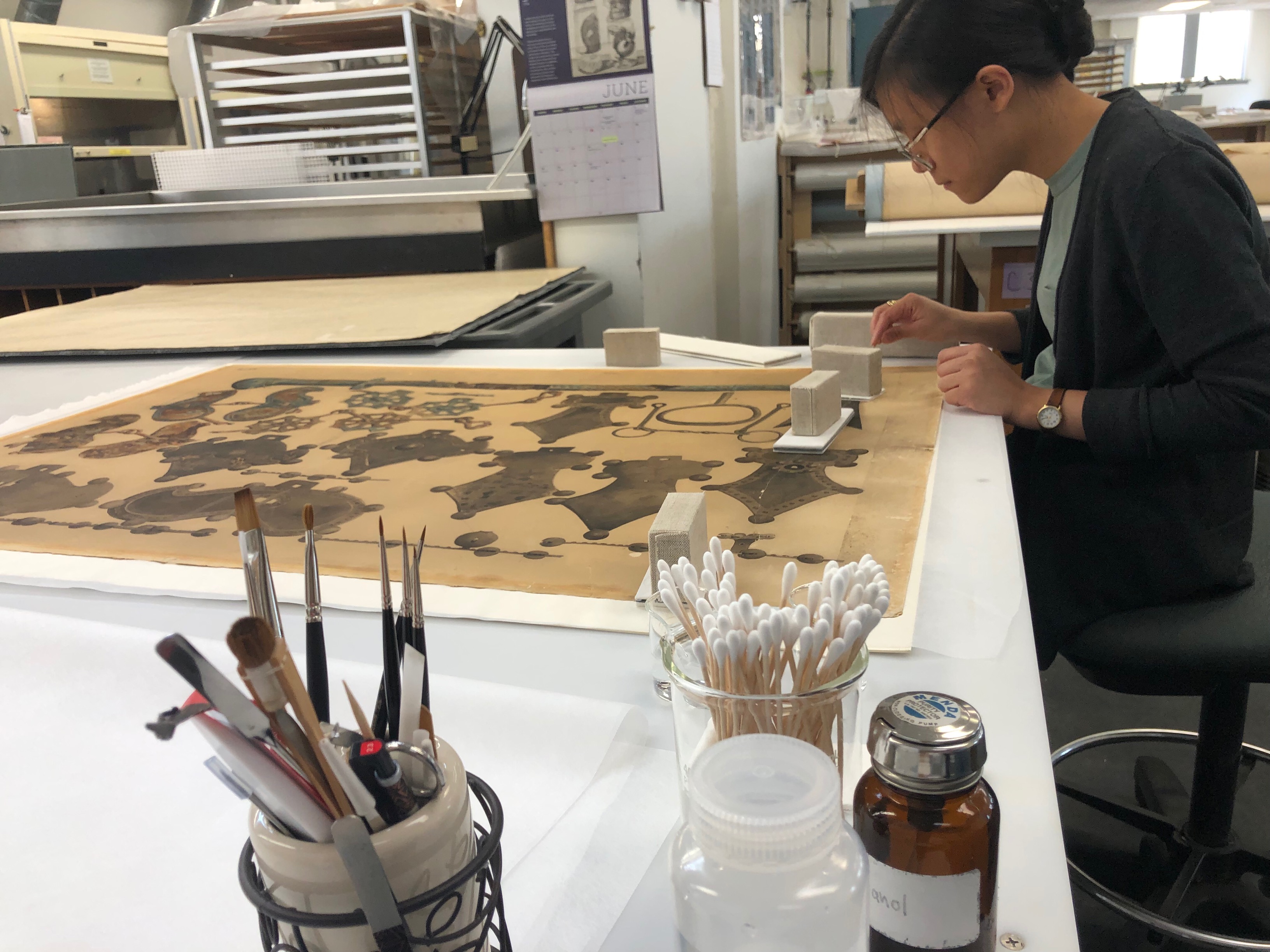 CCAHA Conservation Technician Binh-An Nguyen works on an 1893 Japanese watercolor from the Penn Museum's collections
