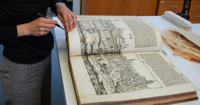 Conservator cleans a large manuscript