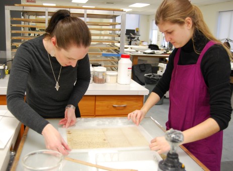 Conservators adjust a document