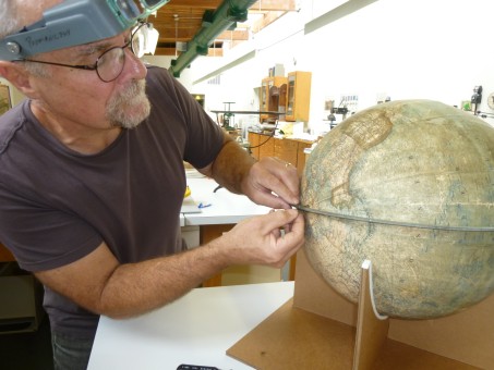 Conservator looks at globe