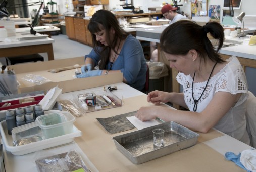 Two conservators treat photographs