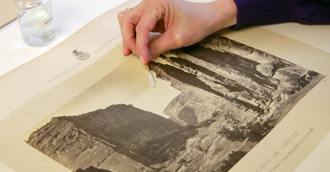 Cleaning a photograph with a cotton swab