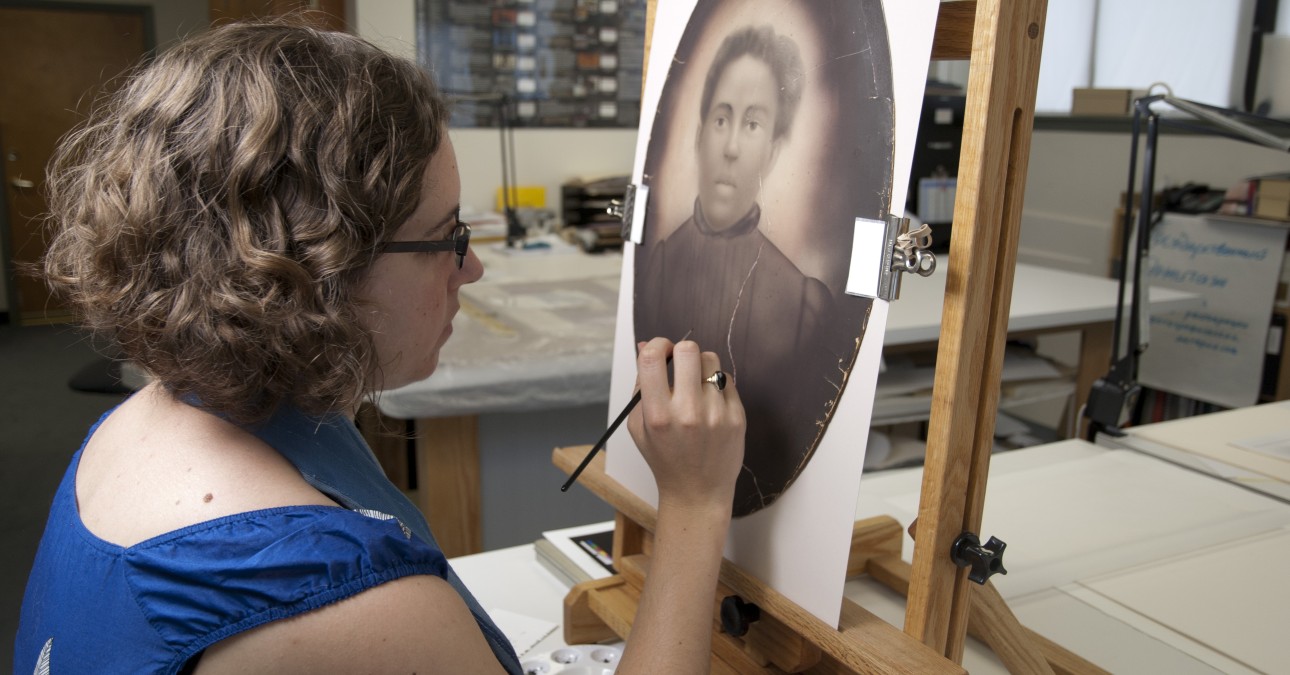 Conservator inpaints a crayon enlargement