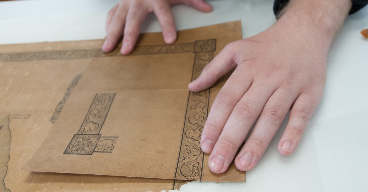 Paper Conservation Fellow Benjamin Kirschner aligns a map corner facsimile