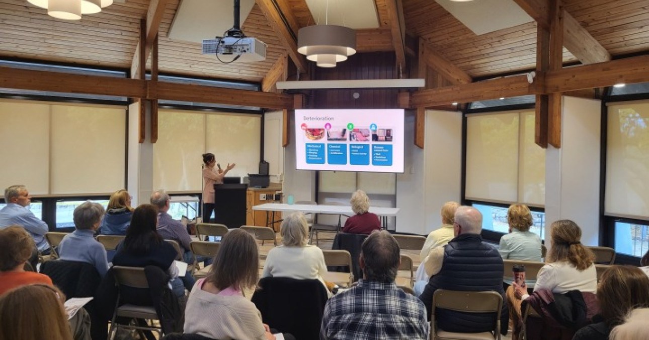 A presenter speaks to a large audience.
