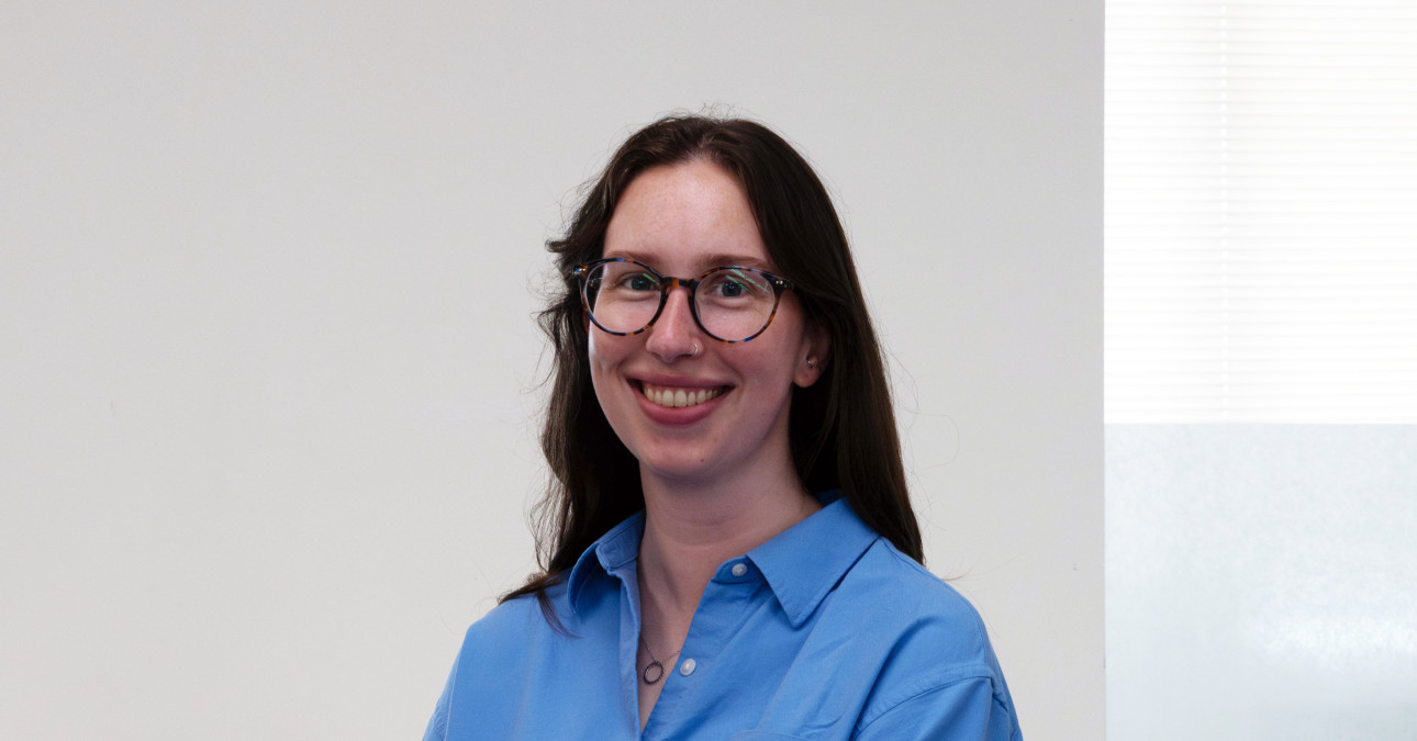 A photo of Ashley Stanford, wearing a blue shirt, in front of a white background.