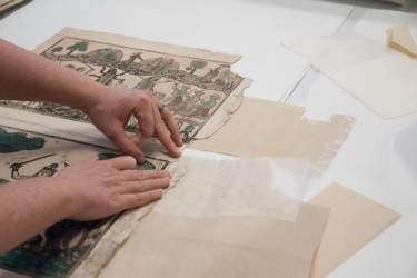 Senior Paper Conservator Heather Hendry examines a variety of paper options to fill a losses