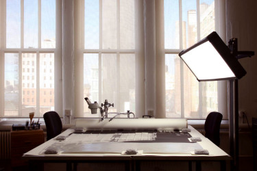 An image of the CCAHA satellite studio in New York City, featuring a table with an object and overhead light.